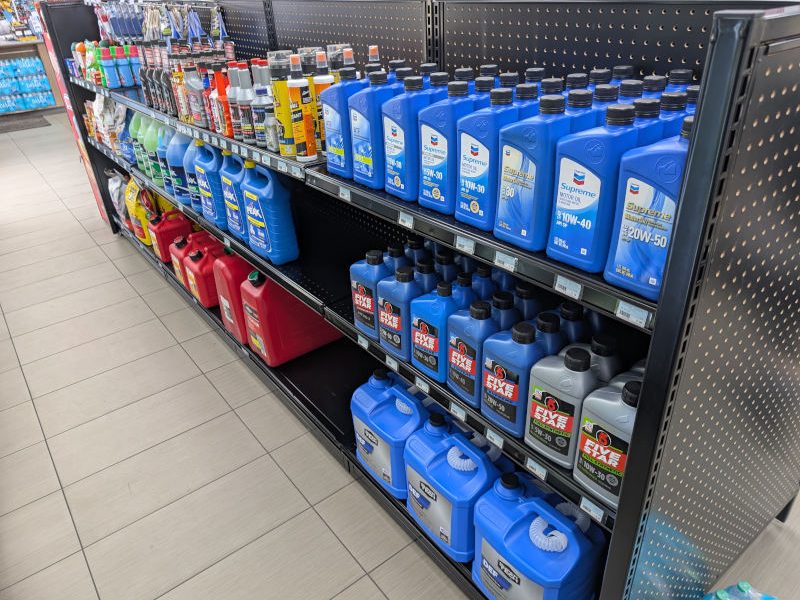 Auto aisle with 54 inch gondola and 16 inch deep steel shelves and black pegboard